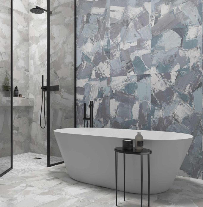 OLEO Baño moderno con bañera blanca, ducha acristalada y paredes de azulejos en tonos grises.
