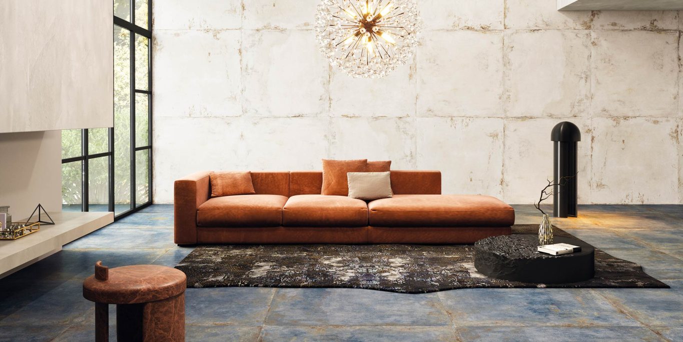 FLAMED Sofá naranja moderno sobre una alfombra negra en un salón minimalista.